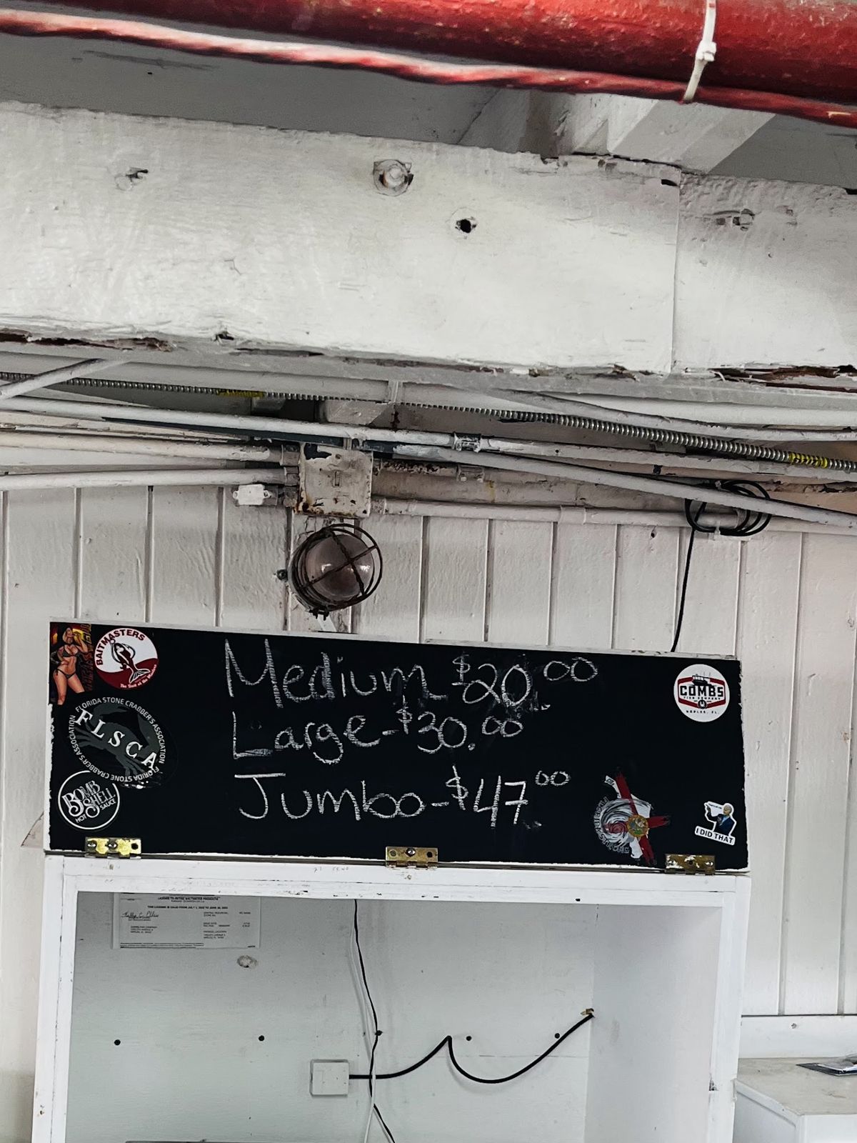 Chalkboard listing medium, large and jumbo claws at the fish house